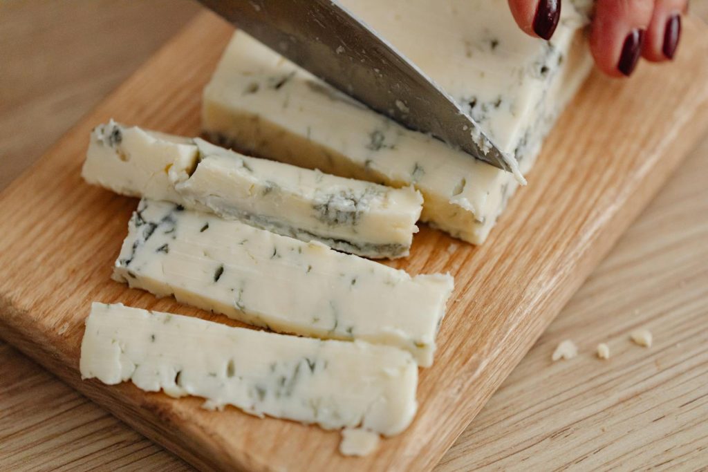 Gorgonzola met karakteristieke blauwe aderen vers gesneden op een houten plank