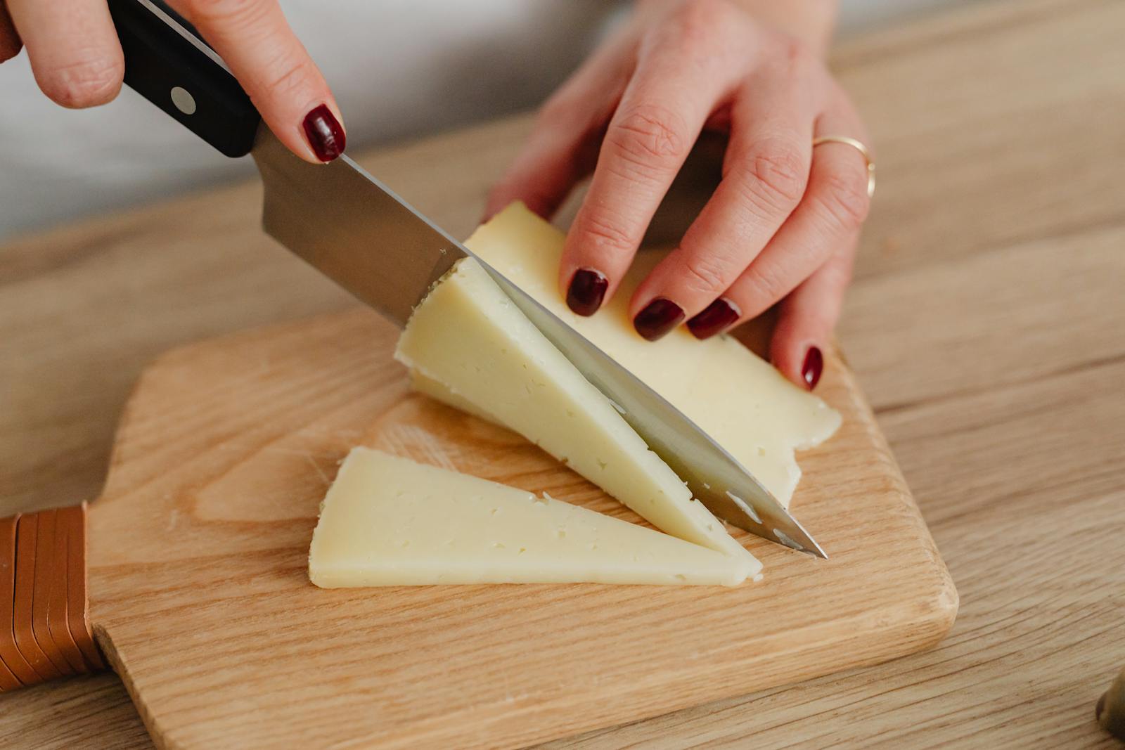 Spaanse Manchego schapenkaas in driehoekige punten gesneden op houten snijplank