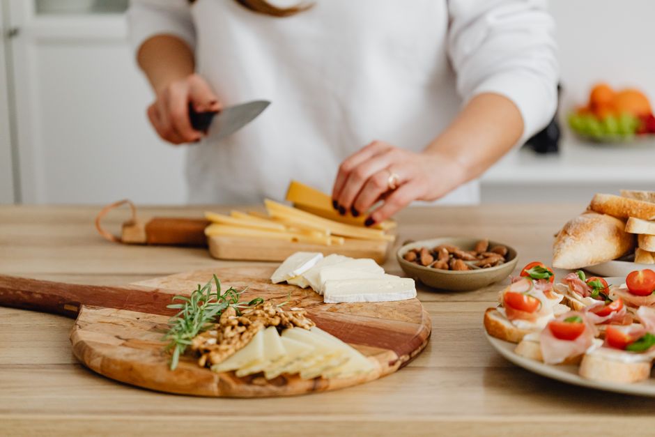 Plakken belegen kaas op een houten borrelplank met noten en brood