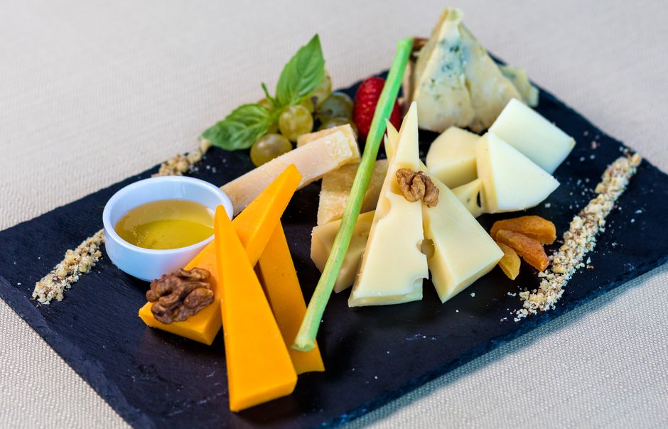 Borrelplank met verschillende kruidenkazen, noten en fruit