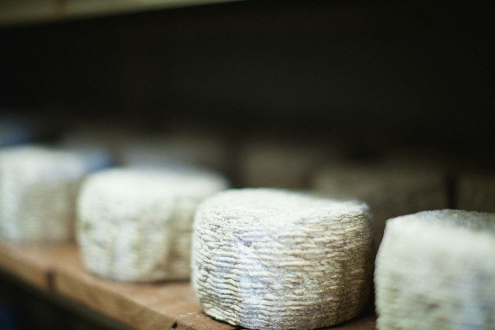 Franse chèvre en Nederlandse geitenkaas naast elkaar op een houten kaasplank