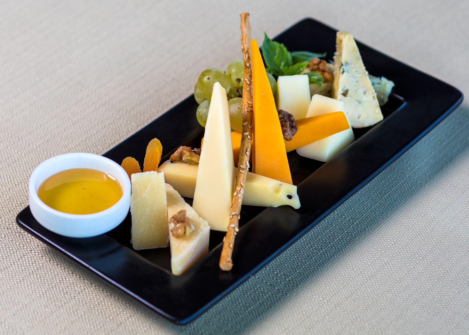 Kaasplank met verschillende soorten geitenkaas, noten en fruit