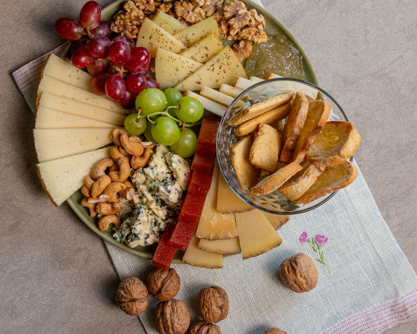 Kaasplank met belegen Goudse kaas, walnoten, druiven en crackers
